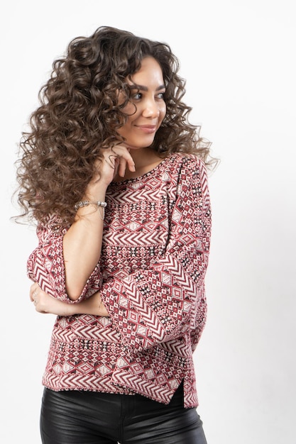 A beautiful young female model with curly long dark hair.