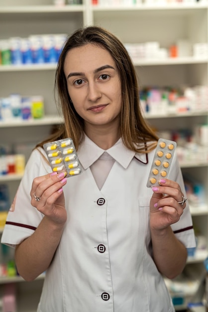 A beautiful young female pharmacist is waiting for visitors in a spacious pharmacy