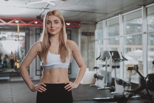 Bella giovane donna fitness allenandovi in palestra