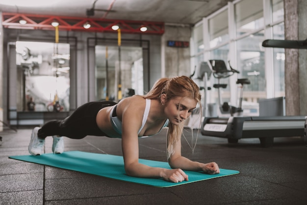 Beautiful young fitness woman working out at the gym