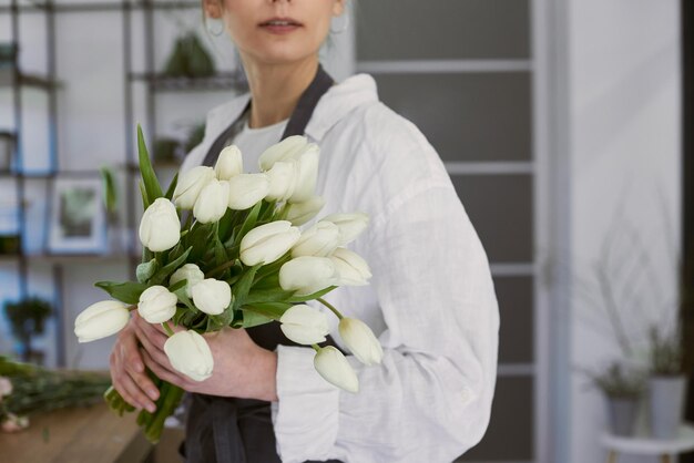 Beautiful young florist makes a bouquet