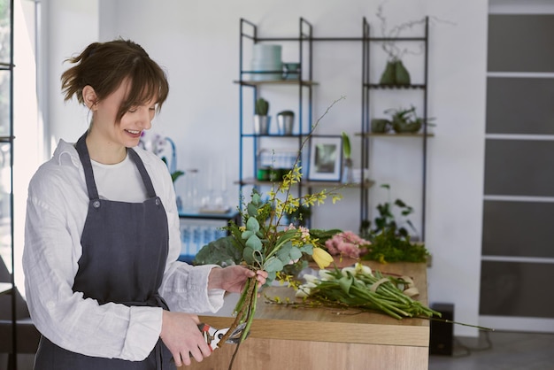 Beautiful young florist makes a bouquet