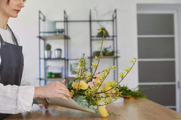 Beautiful young florist makes a bouquet