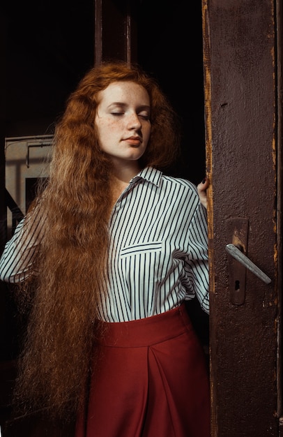 Photo beautiful young ginger model with closed eyes and wavy red hair