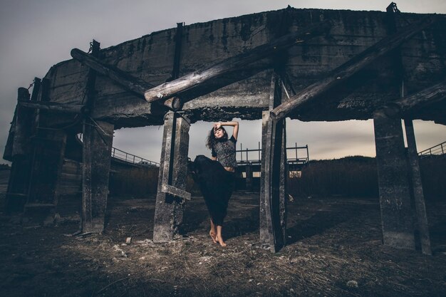 黒い揺れるスカートの干上がった湖のダムの美しい少女