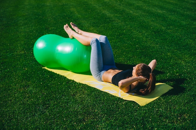 Beautiful young girl doing exercises with fitball