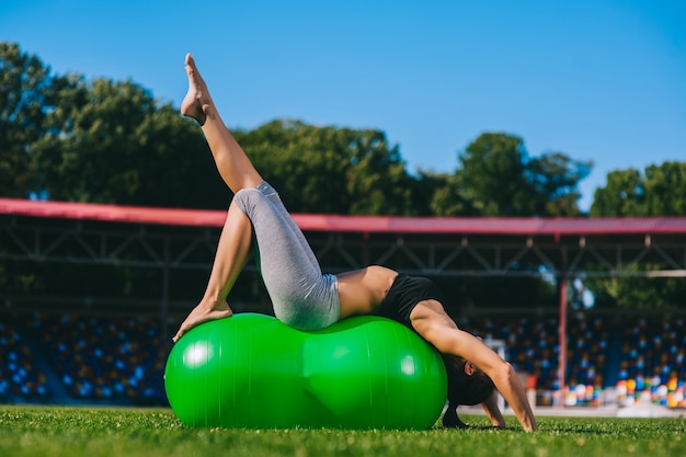 Bella ragazza facendo esercizi con fitball