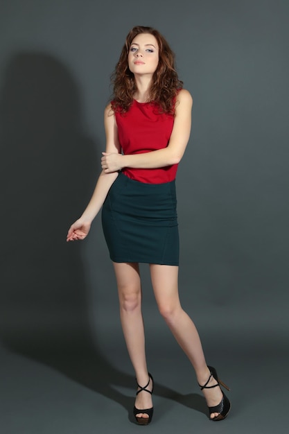 Beautiful young girl in dress on grey background