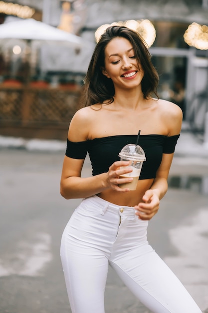 beautiful young girl drinking coffee in the city