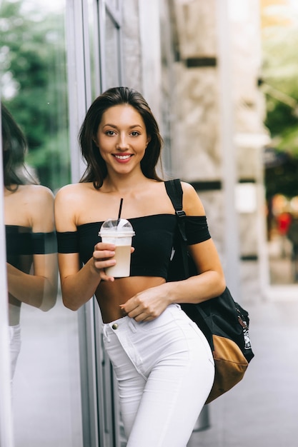 beautiful young girl drinking coffee in the city