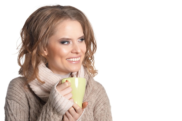 Beautiful young girl drinking tea, against white background