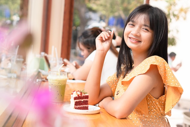 カフェでケーキを食べる美しい若い女の子幸せな女の子
