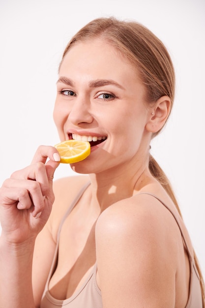 Beautiful young girl enjoying juicy fruits