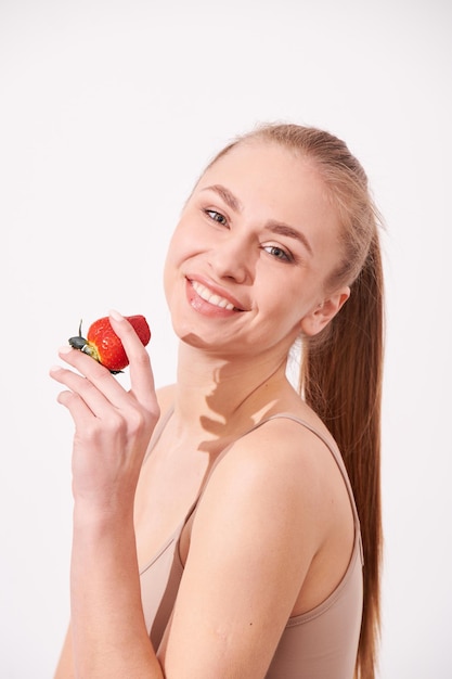 Beautiful young girl enjoying juicy fruits