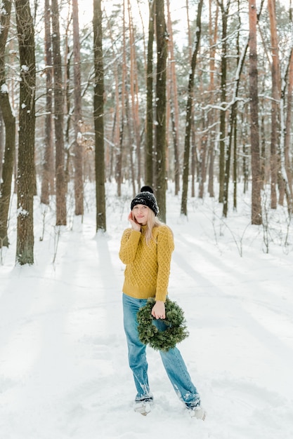야외에서 겨울을 즐기는 아름다운 소녀 숲이나 공원에서 눈으로 즐거운 시간을 보내는 예쁜 여성