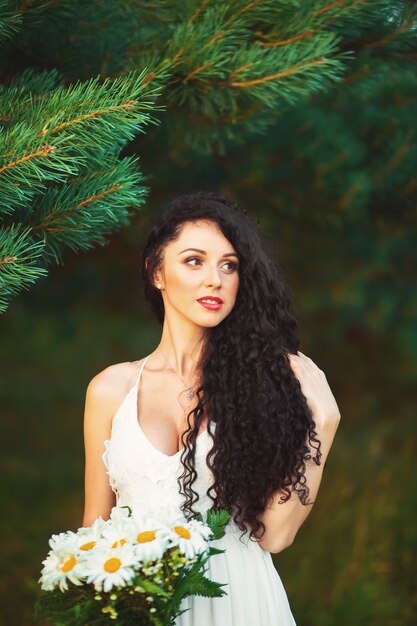 Beautiful young girl in a field in a white dress