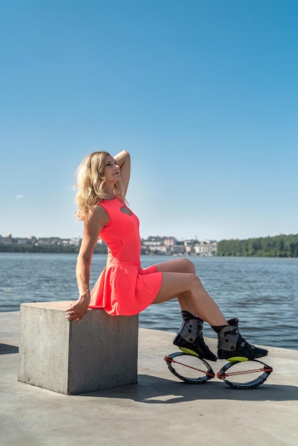 Beautiful young girl fitness trainer with jumping dressed in special shoes resting by the lake