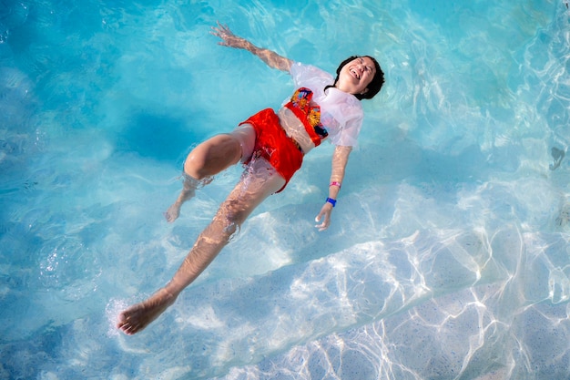 写真 暑い夏の日に彼女の背中にプールに浮かぶ美しい少女