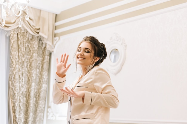 Beautiful young girl in Golden pajamas in a luxurious room