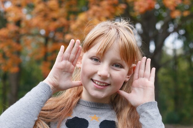 秋の公園で楽しんでいる美しい少女