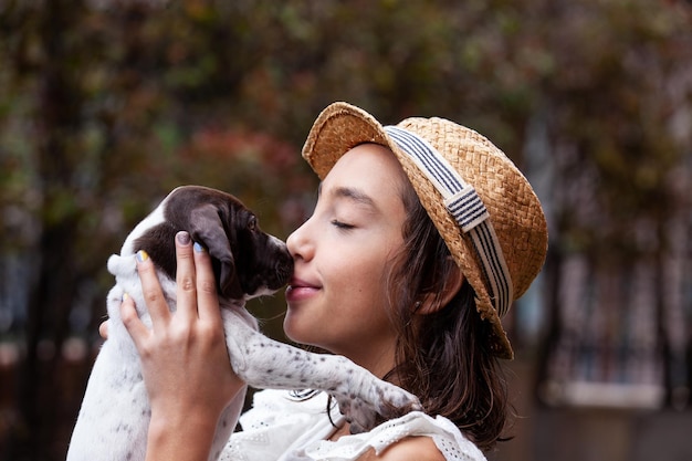 Beautiful young girl having fun with her small french braque puppy