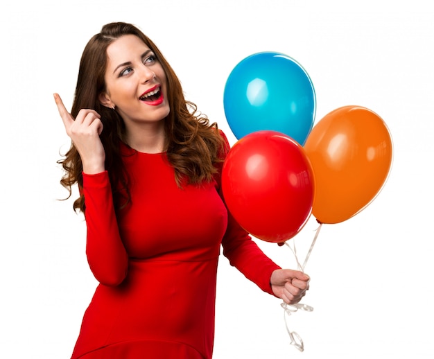 Beautiful young girl holding balloons and thinking