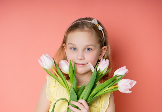 Beautiful young girl holding a bouquet of tulips