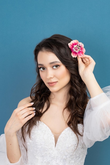 Beautiful young girl holding pink flower buds in her hands