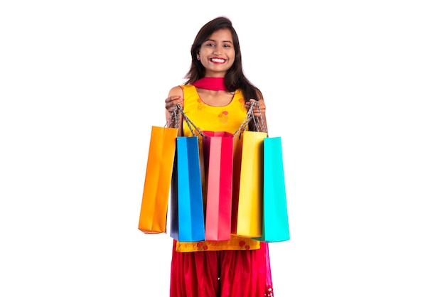 Beautiful young girl holding and posing with shopping bags on a white background