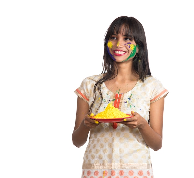 Beautiful young girl holding powdered color in plate on the occasion of Holi festival.