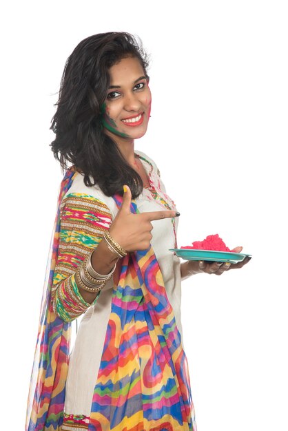 Beautiful young girl holding powdered color in plate on the occasion of Holi festival.