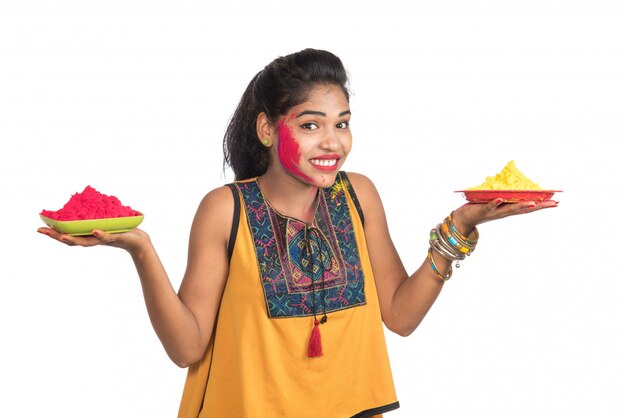 Beautiful young girl holding powdered color in plate on the occasion of Holi festival.