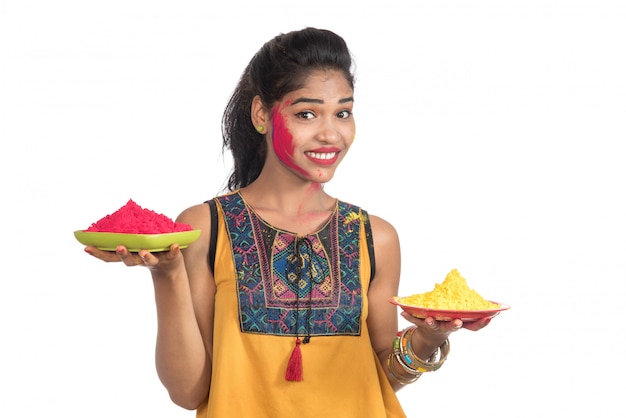 Bella ragazza che tiene il colore in polvere nel piatto in occasione del festival di holi.