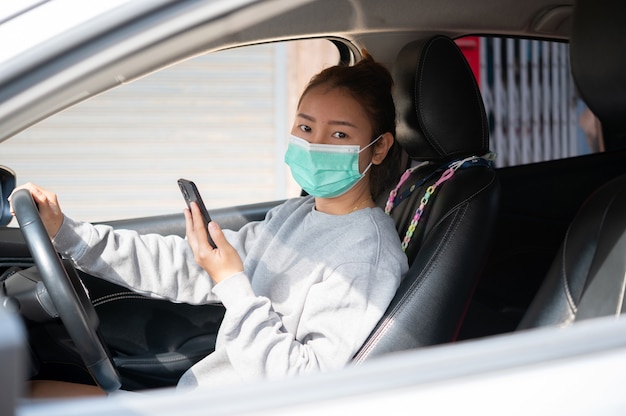 写真 車に座っているマスクの美しい少女、