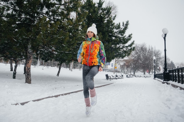 凍てつく雪の日、美しい少女がジョギングをしている。スポーツ、健康的なライフスタイル。