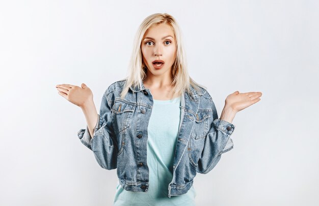 Beautiful young girl is surprised on gray isolated background