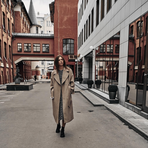 A beautiful young girl is walking in the city in autumn. Spring in the city. Beauty. thunderclouds.