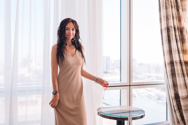 Beautiful young girl in a long dress in hotel room