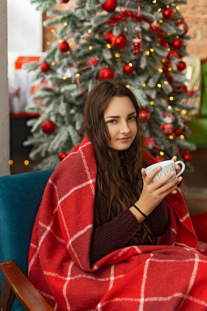 Bella ragazza vicino all'albero di natale