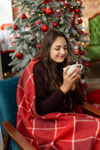 Beautiful young girl near the Christmas tree