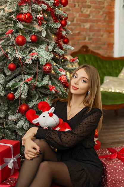 Bella ragazza vicino all'albero di natale