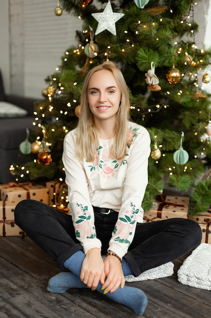 Beautiful young girl near the Christmas tree