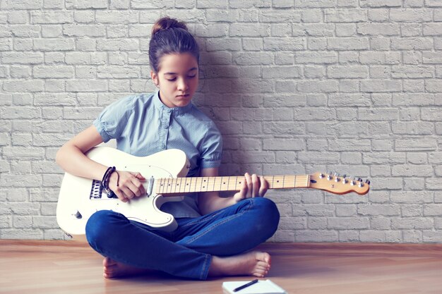 Beautiful young girl playing guitar