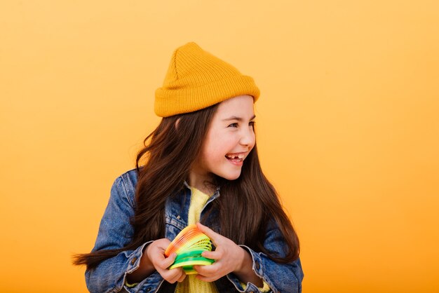 Beautiful young girl playing with a rainbow slinky, a toy of her childhood