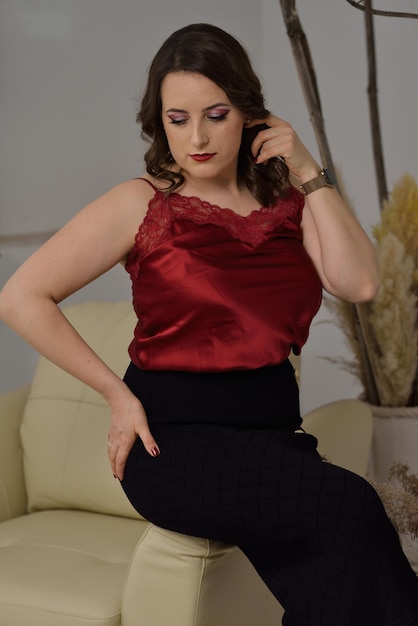 A beautiful young girl posing in a light armchair.