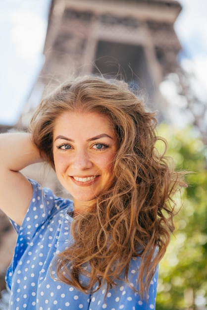 Foto bella ragazza in posa vicino alla torre eiffel