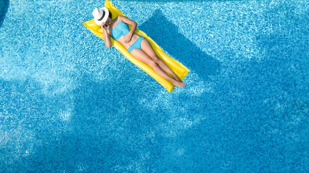 Beautiful young girl relaxing in swimming pool