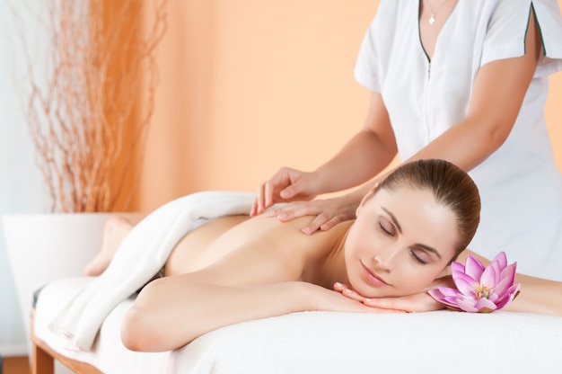 Beautiful young girl relaxing with hand massage at spa during a beauty treatment