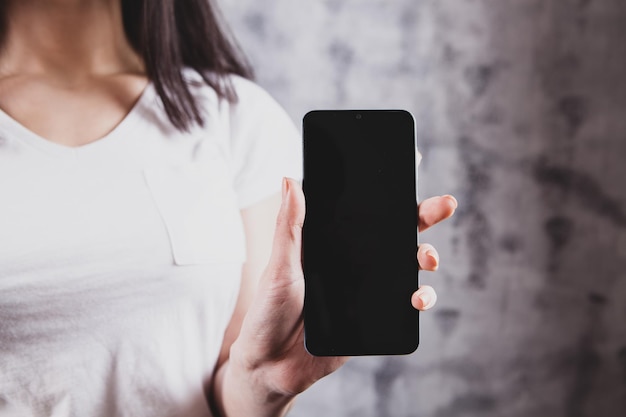 Photo beautiful young girl showing phone