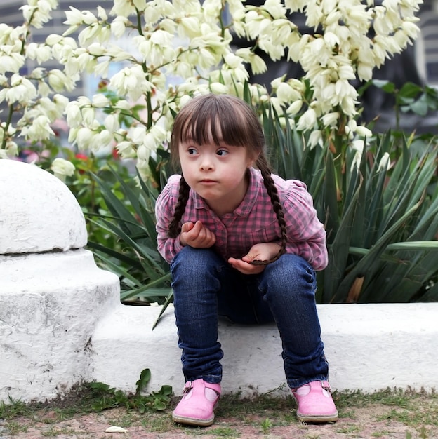 Beautiful young girl siting on flowers background